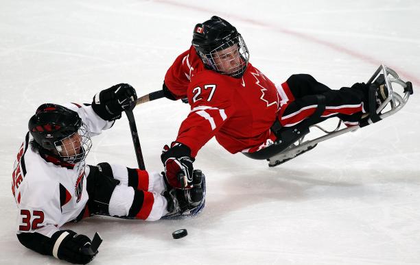 Brad Bowden A picture of a 2 men in a sldege playing hockey