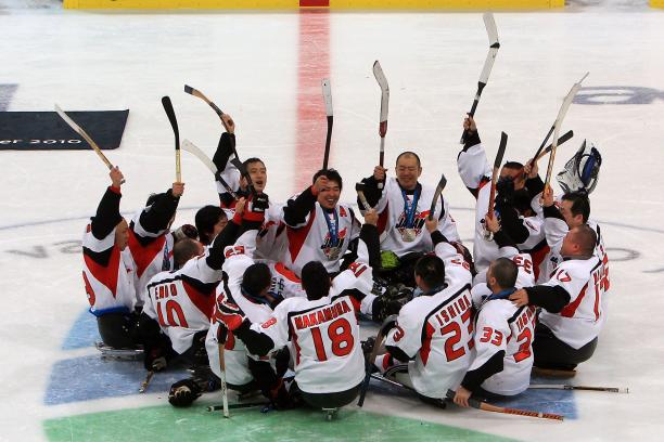 A picture of men playing sledge hockey celebrating their victory