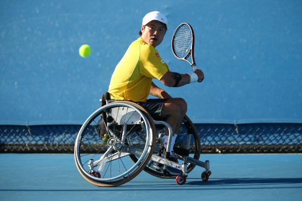 Shingo Kunieda in a wheelchair plays a backhand with his tennis racket