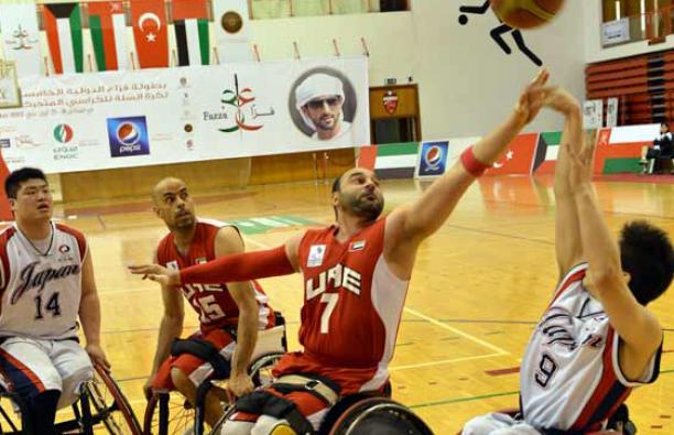 UAE wheelchair basketball A man in a wheelchair shoots a basketball layup.