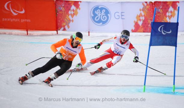 Two skiers behind each other on the slope