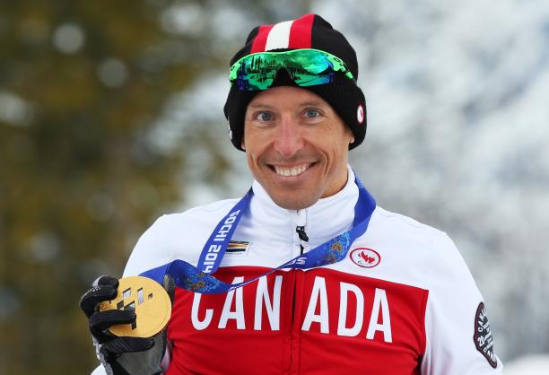 Upper body of smiling man holding medal