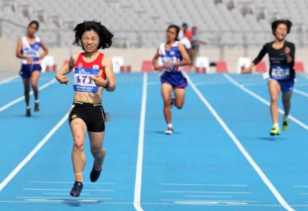 Min-Jae Jeon Korea at Incheon Female runner crosses the finish line on a blue track in a stadium, celebrating