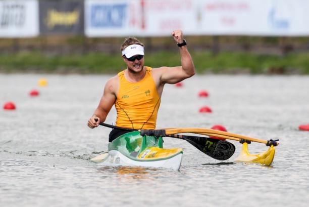 Man in canoe in triumphant pose