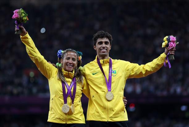 Terezinha Guilhermina A picture of a woman and a man on a podium with medals around their neck