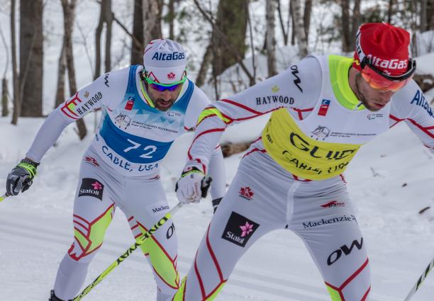 cross country skier and guide climb up a hill