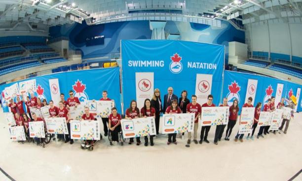 Group shot of athletes and officials in a swim stadium