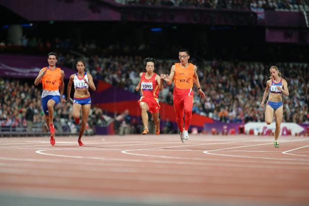 Female runners with guides on a track running