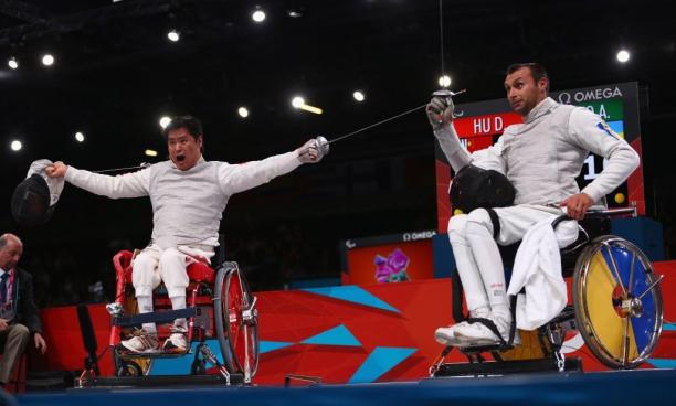 Daoliang Hu (L) of China celebrates winning gold against Anton Datsko (R) of Ukraine during the Men's Individual Foil Category B final of the Wheelchair Fencing on day 6 of the London 2012 Paralympic Games.