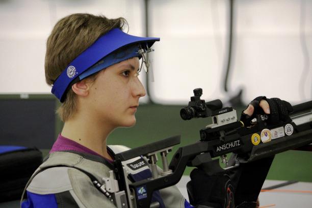 Athlete holding a rifle while practicing shooting.