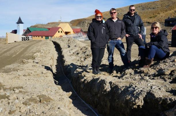 Cardrona general manager, Bridget Legnavsky and Cardrona terrain and snow manager, Dave Collett with Cameron Ross from High Performance Sport NZ and Audi quattro Winter Games NZ sports manager, Iona Bentley next to one of the fibre optic cable channels at Cardrona Alpine Resort 