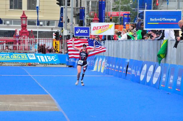 A picture of a woman with a prosthesis wearing an American flag to celebrate her victory