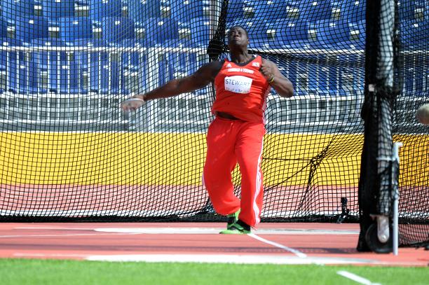 Man in red jersey throwing a discus