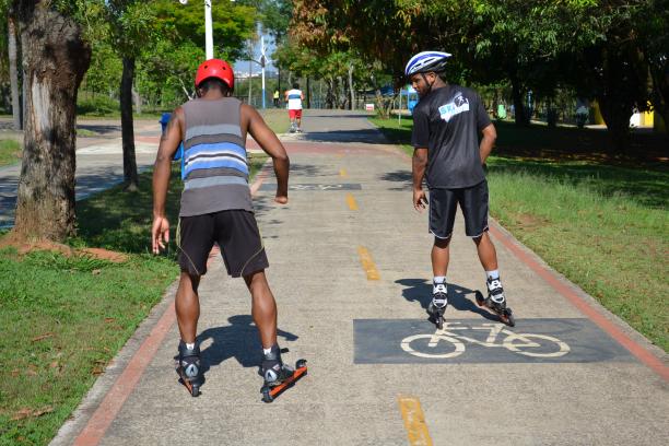 Two men on rollerblades on a bicycle way