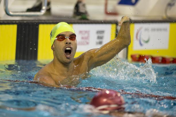 Man in the water, waving one arm in the air, celebrating
