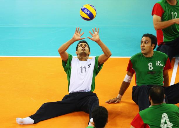 Man hits a volleyball in the air 