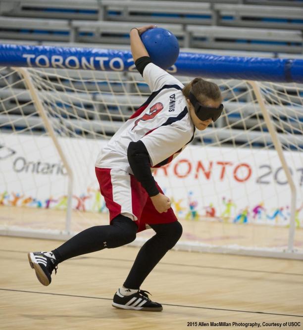 a female wearing white, black and red competing in goalball