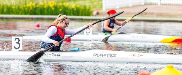 a photo showing the top half of a lady in a canoe wearing a white top, life jacket and sunglasses