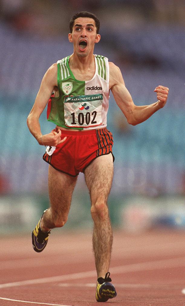 Man in running clothes, crossing a finish line, celebrating