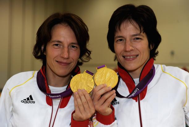 A shot of the upper half of two women holding two Paralympic gold medals