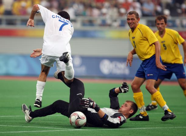 Ukraine goalkeeper Kostyantyn Symashko - football 7 - Beijing Man on the ground. other man jumping over him. Both focusing on a ball