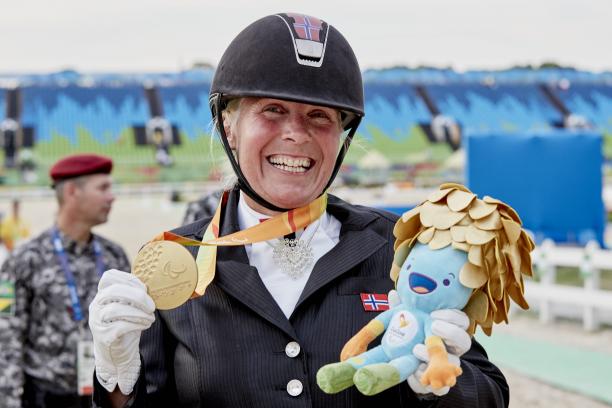 A dressage rider celebrating her medal.