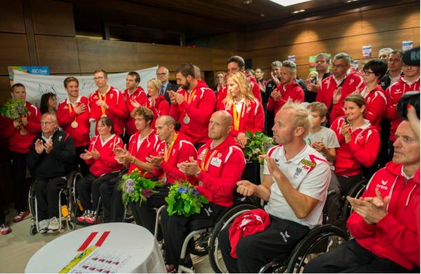 A group of athletes is welcomed by sports dignitaries