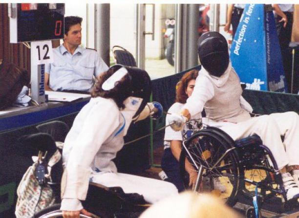 Two people in wheelchairs, fencing