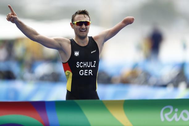 Germany's Martin Schulz - triathlon Man with missing left forearm races arms as he is about to cross a finish line