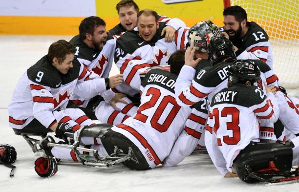 A group of Para ice hockey players celebrating.