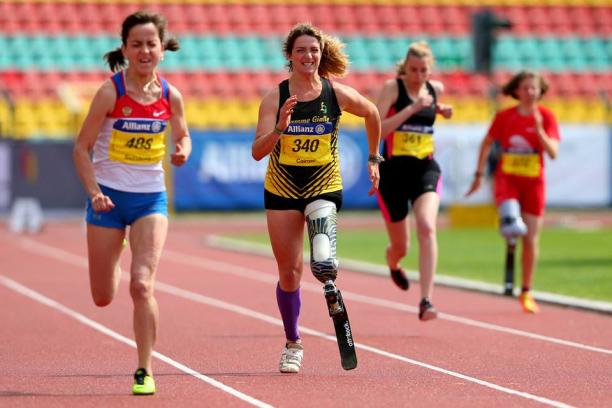 Martina Caironi A woman with a running blade clenches her face in effort as she sprints forward.
