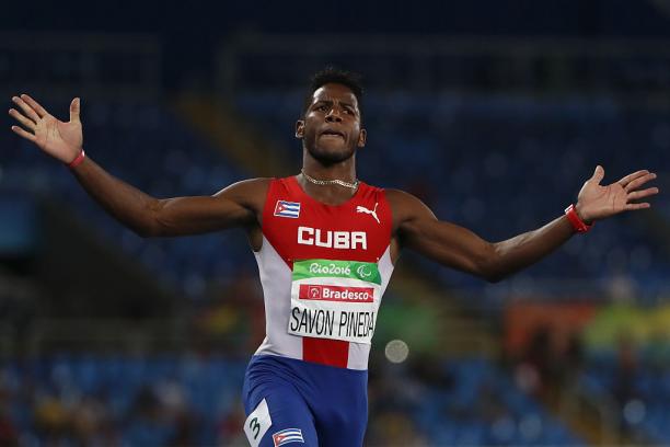 male sprinter crosses finish line with arms outstretched