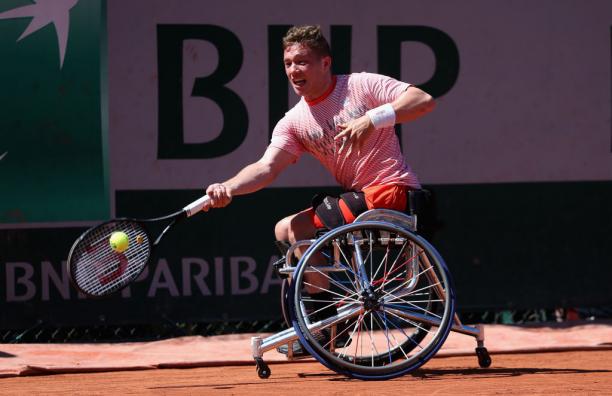 a wheelchair tennis player hits the ball