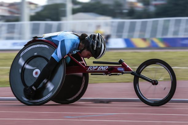 female wheelchair racer on track with head down