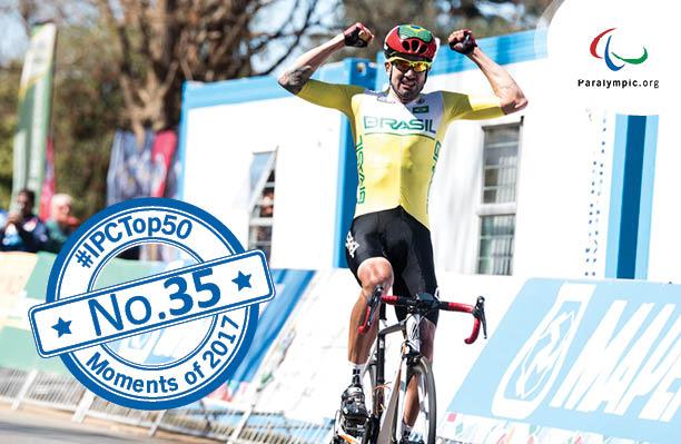 Top 50 Moments - No 35 Lauro Chaman a male Para cyclist raises his arms in celebration as he crosses the finish line