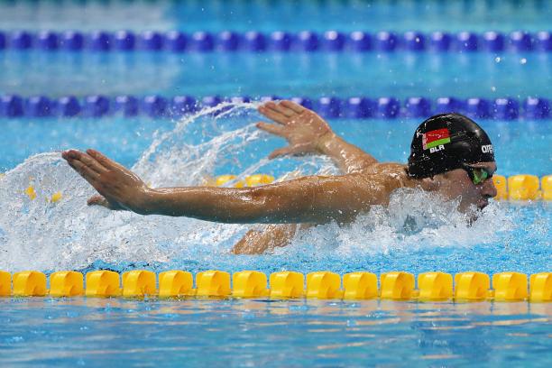 Male swimmer in water competing in butterfly stroke