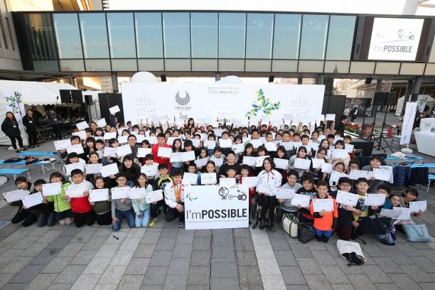 I'mPOSSIBLE - 1,000 days to go a group of schoolchildren holding up signs