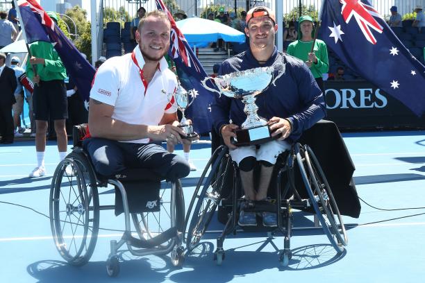 two male wheelchair tennis players hold up their trophies