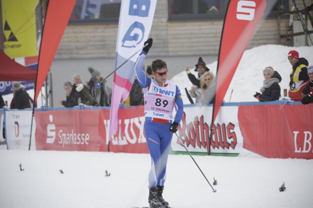 Benjamin Daviet - Oberried 2018 a male Para Nordic skier raises his arms in celebration as he crosses the finish line