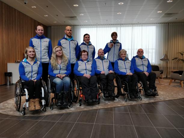 Team Finland for PyeongChang 2018 Paralympic Winter Games Four people standing behind a group of six people in wheelchairs