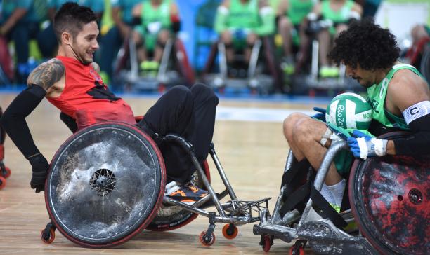 two male wheelchair rugby players clash for the ball