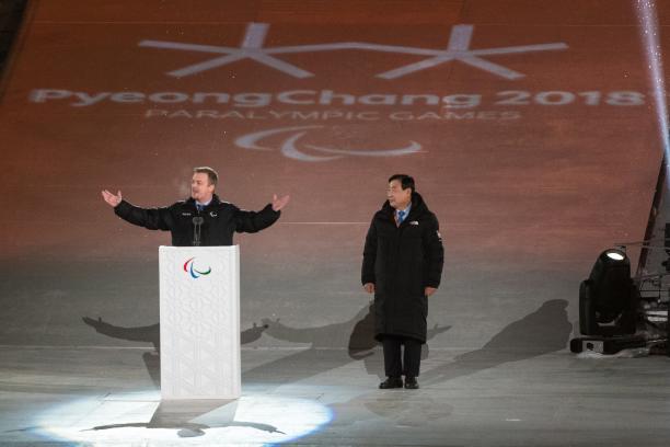 Andrew Parsons at PyeongChang 2018 Opening Ceremony a man spreads his arms wide while speaking at a podium