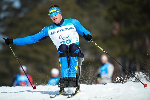 a male sit skier ploughs through the snow