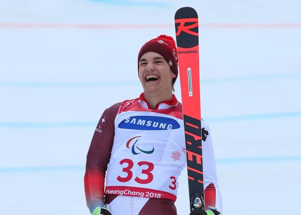a male Para skier laughs in celebration