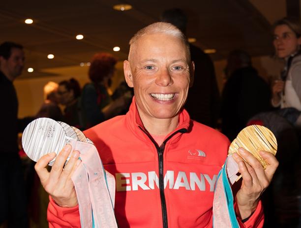 Andrea Eskau returns a female athlete holds up her six Paralympic medals