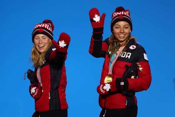 two female Nordic skiers wave from the podium