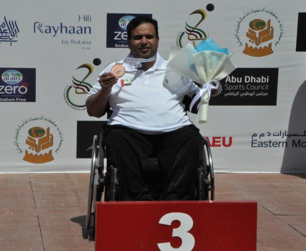 Abdulla Sultan Alaryani - UAE shooting Man in wheelchair holding medal and flowers