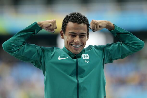 Daniel Martins a male athlete raises his fists on the podium