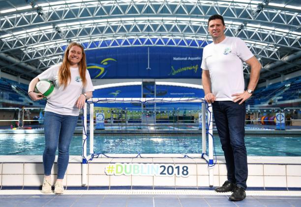 A woman and a man standing in front of a swimming pool