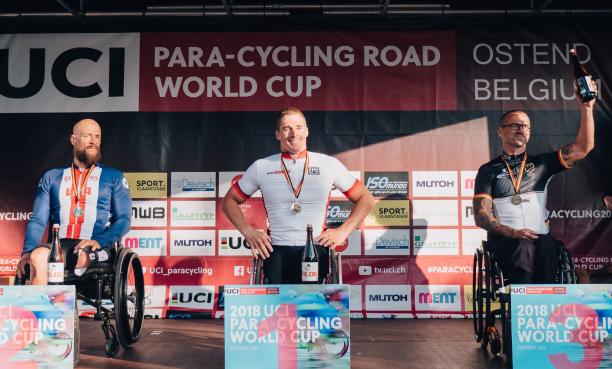 three male Para cyclists on the podium